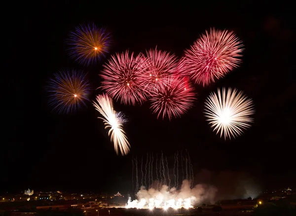 Fireworks in noisy background.Colorful fireworks in Malta with house light in the far, Malta fireworks festival, 4 of July, Independence day, New Year, maltese fireworks.Zurrieq, Malta — Stock Photo, Image