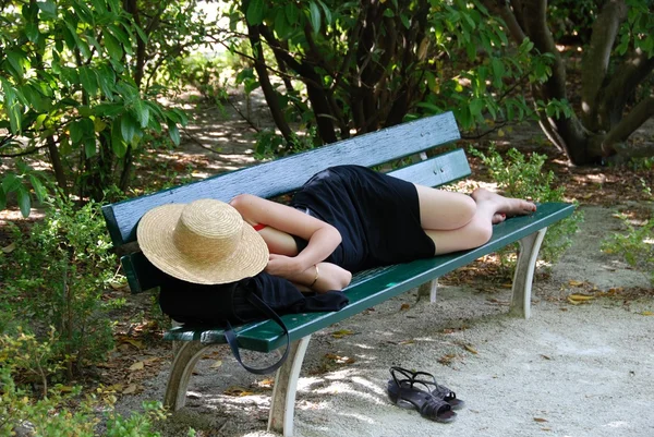 Güneşli günde bir masada uyuyan kadın. Siesta kadınlarda. Öğle yemeği zamanı İspanya 