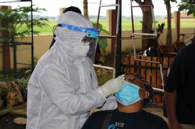 Sağlık çalışanları 30 Aralık 2020 'de Pekalongan Endonezya sakinleri üzerinde antijen numune testleri yapıyor.