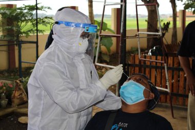 Sağlık çalışanları 30 Aralık 2020 'de Pekalongan Endonezya sakinleri üzerinde antijen numune testleri yapıyor.