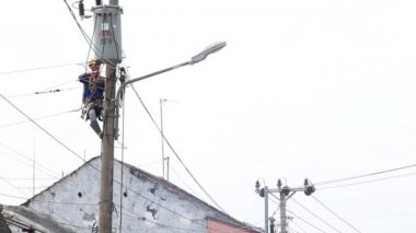 Bulanık ve gürültü klipsi, elektrik direği, Pekalongan, Endonezya, 27 Ocak 2021 'de elektrik direğinde çalışan elektrik teknisyeni tamircisi.