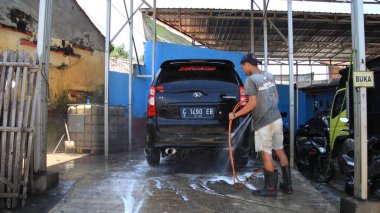 İşçi araba temizliği, sprey sıkma ve silme, işyerinde, Batang, 27 Şubat 2021