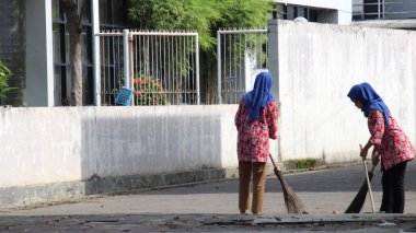 İşçi, ofisinin bahçesini temizler, pislikten ve çöpten temizler, Pekalongan, Endonezya, 7 Mart 2021