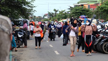 Fabrika işçileri işten eve gelir, 22 Şubat 2021 'de Pekalongan caddesindeki motosikletlerine yürürler.