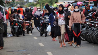 Fabrika işçileri işten eve gelir, 22 Şubat 2021 'de Pekalongan caddesindeki motosikletlerine yürürler.