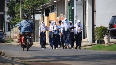 Odaklanamıyorum, liseli çocuklar okulda okuduktan sonra yürüyorlar, maske takıyorlar, Pekalongan, Endonezya, 16 Mart 2021