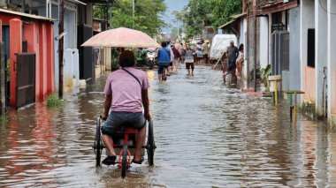 18 Şubat 2021 'de Pekalongan' da selden geçen birkaç motosikletli ve arabalı bulanık görüntü.