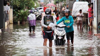 18 Şubat 2021 'de Pekalongan' da selden geçen birkaç motosikletli ve arabalı bulanık görüntü.