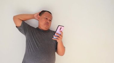Adam akıllı telefonunu kullanarak mesajları okumakla meşguldü, stresli bir ifadeyle.