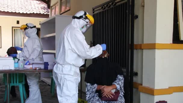 2020年11月19日 印度尼西亚Pekalongan 身着防护服的医生从一个人身上取出鼻涕 检查是否有可能感染了考拉病毒 — 图库视频影像