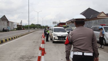 Endonezya Ulusal Polisi ve Silahlı Kuvvetler 'in güvenlik görevlileri, 17 Haziran 2021' de Covid 19, Pekalongan 'ın transmisyonu için kontrol edilmek üzere Toll Road' dan ayrılan araçları durdurdular.