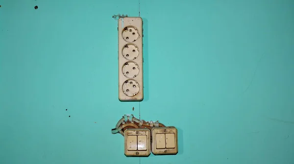 Wall switch. Power electrical socket, stuck to the wall, it\'s old and dirty