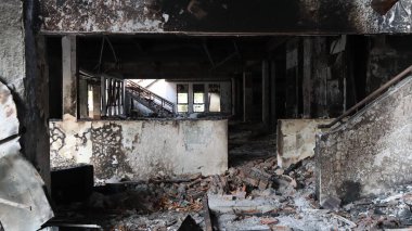 Yangından sonra yıkıntılar arasında kalan bina yıkımı ve hasarı simgeliyor. Kaybı ve felaketin sonrasını sembolize ediyor..