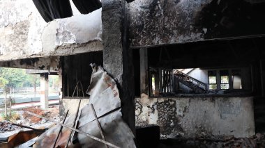 Yangından sonra yıkıntılar arasında kalan bina yıkımı ve hasarı simgeliyor. Kaybı ve felaketin sonrasını sembolize ediyor..