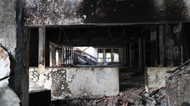 Yangından sonra yıkıntılar arasında kalan bina yıkımı ve hasarı simgeliyor. Kaybı ve felaketin sonrasını sembolize ediyor..