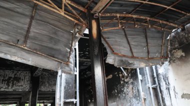 Yangından sonra yıkıntılar arasında kalan bina yıkımı ve hasarı simgeliyor. Kaybı ve felaketin sonrasını sembolize ediyor..