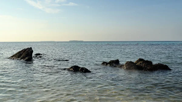 Huzurlu bir sabahta, kıyı kenarındaki turkuaz deniz, sakin ve doğal bir deniz manzarası yaratıyor..