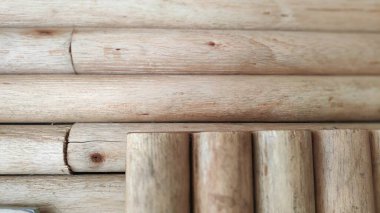 Tahta direkler yatay ve dikey olarak sıralanmış doğal ahşap tanecikli ve sıcak, toprak tonlu organik tasarım için ideal bir yüzey oluşturuyorlar..