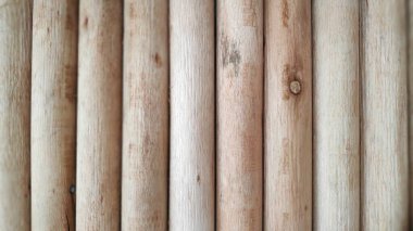 Tahta direkler yatay ve dikey olarak sıralanmış doğal ahşap tanecikli ve sıcak, toprak tonlu organik tasarım için ideal bir yüzey oluşturuyorlar..