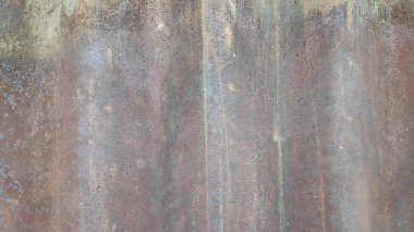 Çürümüş metal levhalar endüstriyel bir ortamda paslanma ve aşınma gösteriyor, yıpranmanın ve yaşın etkilerini gösteriyor, dokulu ve yıpranmış bir görünüm yaratıyor..