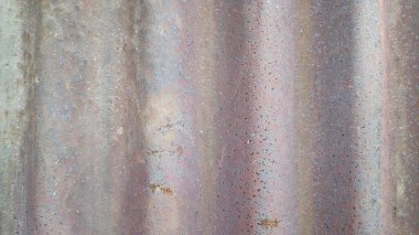 Çürümüş metal levhalar endüstriyel bir ortamda paslanma ve aşınma gösteriyor, yıpranmanın ve yaşın etkilerini gösteriyor, dokulu ve yıpranmış bir görünüm yaratıyor..