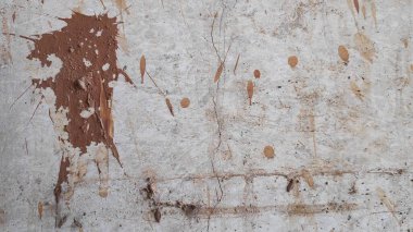 Soyut desenli yüzey açık gri bir zemin üzerinde lekeler ve kahverengi boya lekeleri sergiler, ham ve sanatsal bir etki yaratır.