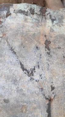 Paslı metal levha, yıpranmış materyal üzerindeki aşınmış desenlerle dokulu yüzeyi göstererek soyut ve endüstriyel bir estetik yaratıyor..