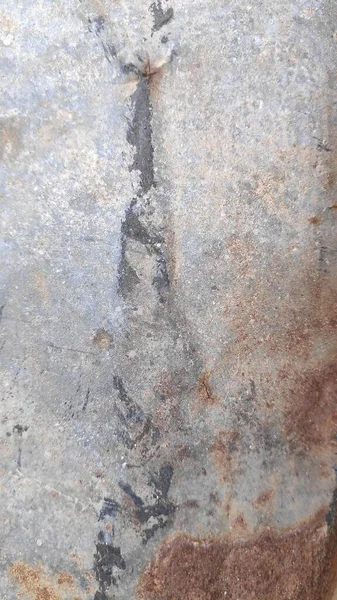 Paslı metal levha, yıpranmış materyal üzerindeki aşınmış desenlerle dokulu yüzeyi göstererek soyut ve endüstriyel bir estetik yaratıyor..