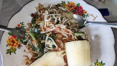 Gadogado tabağında Cassava kekleriyle servis edilen geleneksel Endonezya mutfağını canlı ve renkli bir sunumla gösteriyor..