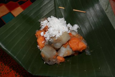 Endonezya usulü aperatif 'kue getuk telo' muz yaprağında haşlanmış kasava karışımı, üzerinde rendelenmiş hindistan cevizi, tatlı ve lezzetli bir karışım yaratarak geleneksel mutfak sanatını sergiliyor..