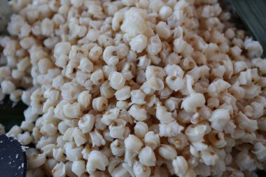 Muz yaprağının üzerinde küçük bir bardak hominy ve kaşık eşliğinde doğal malzemeler ve kırsal cazibeyle geleneksel yemek hazırlığı sergileniyor..