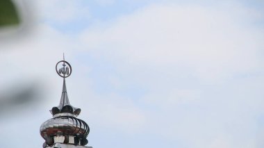 Cami minaresi, dinsel mimaride bulutlu gökyüzüne doğru aydınlık ve bulutlu bir güne ulaşarak dingin atmosferdeki inanç ve maneviyatı sembolize eder..