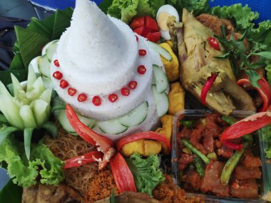 Geleneksel bir Endonezya yemeği olan Nasi tumpeng koni şeklinde pirinç tabağıdır. Çeşitli mezeler ve sebzelerle servis ediliyor. Muz yapraklarıyla kaplı bir sepette daire şeklinde dizilmiş..