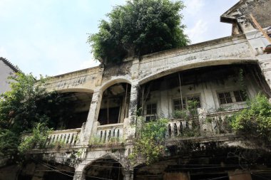 Seine nehri üzerindeki antik bir taş köprüde tarihi Avrupa mimarisi ve yeşil bir doğa manzarası ve parkın ortasında eski ahşap yapı sergileniyor.