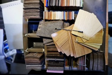 Hırdavatçılarda her zaman mevcut olan boya satın alma seçenekleri için çeşitli renklerde bir kağıt yığını.