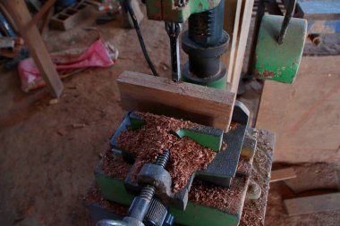 Paslı testereler ve eski metal inşaat araçları da dahil olmak üzere klasik endüstriyel ekipmanlar, geleneksel bir marangozun garajında yıpranmış demir parçaları arasında yer alıyor..