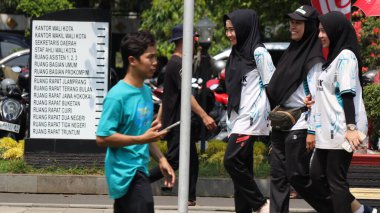 Birlikte duran bir grup insan. Hepsi gülümsüyor ve gösterinin ya da ilginç aktivitenin tadını çıkarıyor gibi görünüyorlar, Pekalongan Endonezya, 14 Ağustos 2025