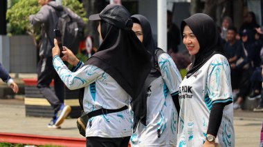 Birlikte duran bir grup insan. Hepsi gülümsüyor ve gösterinin ya da ilginç aktivitenin tadını çıkarıyor gibi görünüyorlar, Pekalongan Endonezya, 14 Ağustos 2025