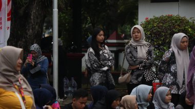 Birlikte duran bir grup insan. Hepsi gülümsüyor ve gösterinin ya da ilginç aktivitenin tadını çıkarıyor gibi görünüyorlar, Pekalongan Endonezya, 14 Ağustos 2025