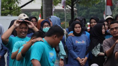 Birlikte duran bir grup insan. Hepsi gülümsüyor ve gösterinin ya da ilginç aktivitenin tadını çıkarıyor gibi görünüyorlar, Pekalongan Endonezya, 14 Ağustos 2025