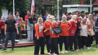 Birlikte duran bir grup insan. Hepsi gülümsüyor ve gösterinin ya da ilginç aktivitenin tadını çıkarıyor gibi görünüyorlar, Pekalongan Endonezya, 14 Ağustos 2025