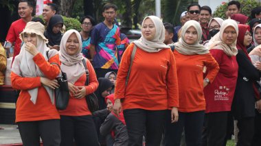 Birlikte duran bir grup insan. Hepsi gülümsüyor ve gösterinin ya da ilginç aktivitenin tadını çıkarıyor gibi görünüyorlar, Pekalongan Endonezya, 14 Ağustos 2025