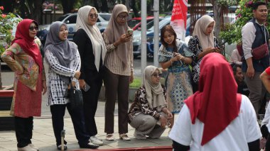 Birlikte duran bir grup insan. Hepsi gülümsüyor ve gösterinin ya da ilginç aktivitenin tadını çıkarıyor gibi görünüyorlar, Pekalongan Endonezya, 14 Ağustos 2025