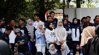 Birlikte duran bir grup insan. Hepsi gülümsüyor ve gösterinin ya da ilginç aktivitenin tadını çıkarıyor gibi görünüyorlar, Pekalongan Endonezya, 14 Ağustos 2025