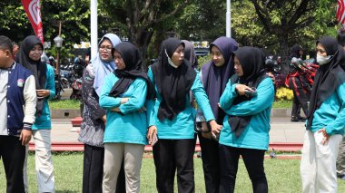 Birlikte duran bir grup insan. Hepsi gülümsüyor ve gösterinin ya da ilginç aktivitenin tadını çıkarıyor gibi görünüyorlar, Pekalongan Endonezya, 14 Ağustos 2025