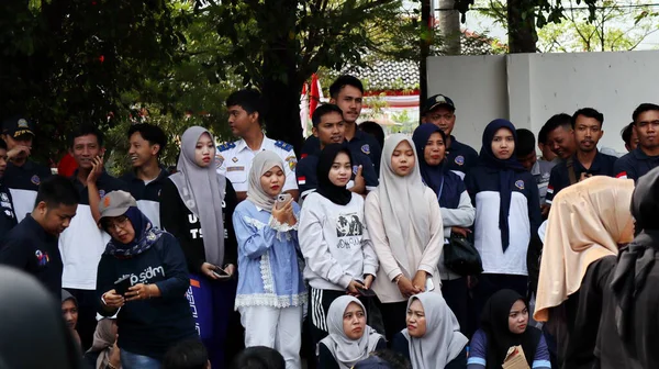 Birlikte duran bir grup insan. Hepsi gülümsüyor ve gösterinin ya da ilginç aktivitenin tadını çıkarıyor gibi görünüyorlar, Pekalongan Endonezya, 14 Ağustos 2025