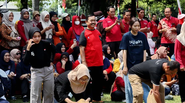 Birlikte duran bir grup insan. Hepsi gülümsüyor ve gösterinin ya da ilginç aktivitenin tadını çıkarıyor gibi görünüyorlar, Pekalongan Endonezya, 14 Ağustos 2025