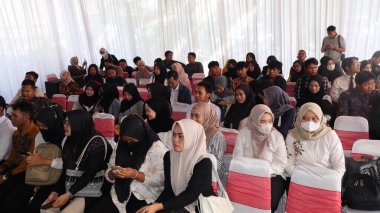 Kalabalık bir iş fuarı kayıt alanında sabırla kuyruğa giren adaylar, bir iş fuarında kayıt olmak için sırada bekliyorlar, kariyer fırsatları için özgeçmiş ve belgeler hazırlıyorlar, Pekalongan, 27 Ağustos 2025