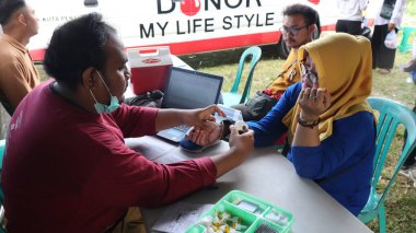 Cemaat üyesi bir mobil kan bağışı aracında kan bağışında bulunurken, tıbbi ekipman gönüllü bağış kampanyası için kan toplarken, tıbbi ekipman da 29 Ağustos 2025 'te, Pekalongan, Endonezya' da bir koltukta dinleniyor.