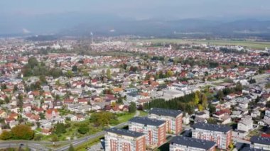 Slovenya 'nın büyük Domzale kenti üzerinde gündüz vakti aşağıdaki konut evleri ve binalarla birlikte havadan çekilen görüntüler.